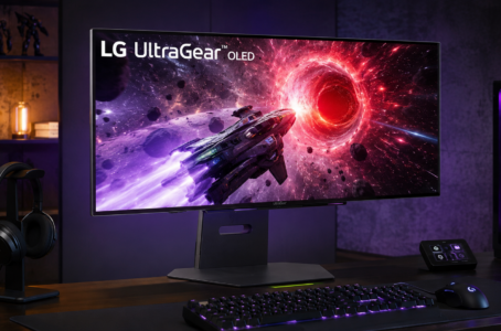 Futuristisches Gaming-Setup mit großem LG UltraGear OLED-Monitor auf dunklem Schreibtisch, beleuchtet mit violettem Ambientelicht und Sci-Fi-Spielgrafik auf dem Bildschirm.
